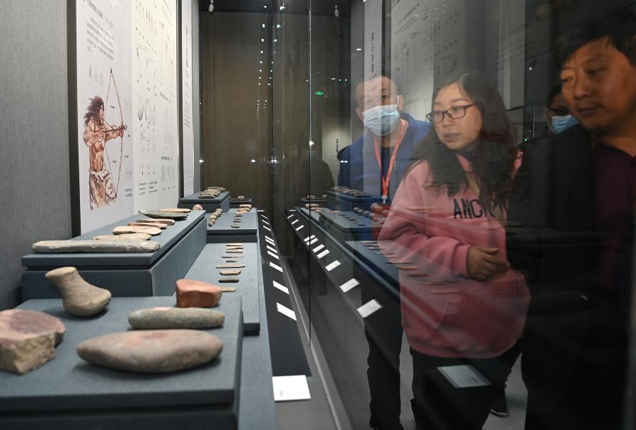 Visitatori osservano i reperti in mostra al Museo della Cultura Yangshao nel parco archeologico nazionale del villaggio di Yangshao nella contea di Mianchi, nella provincia dello Henan, Cina centrale. (17 ottobre 2021 - Xinhua/Li He)
