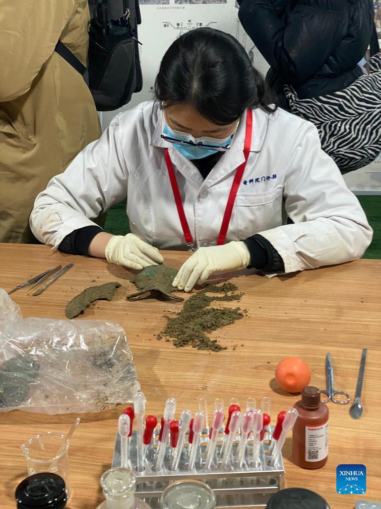 Un'archeologa pulisce un reperto portato alla luce nel sito di Liulihe a Beijing. (7 dicembre 2021 - Xinhua/Luo Xin)