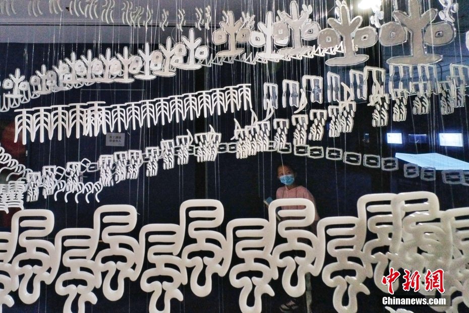 Una bambina apprezza la scultura sospesa ispirata alle iscrizioni su ossi oracolari a Tianjin. (3 gennaio 2022 – China News Service/Tong Yu)