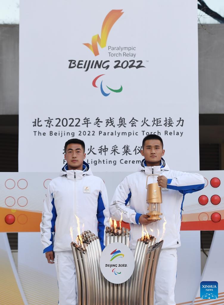 I membri dello staff mostrano la fiamma durante la cerimonia della staffetta della torcia paralimpica e dell'accensione della fiamma di Beijing 2022 presso la China Braille Library di Beijing, capitale della Cina. (2 marzo 2022-Xinhua/Tao Xiyi) 