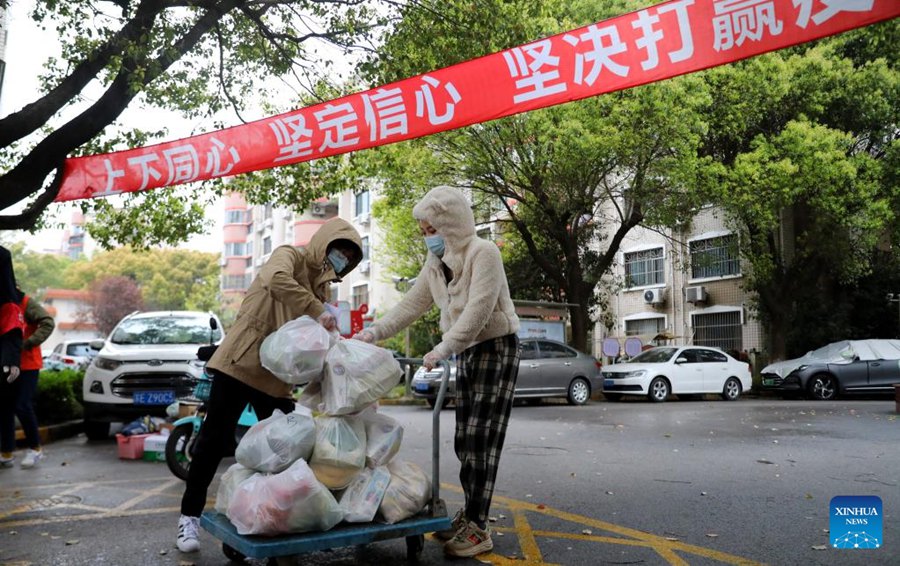 Volontari consegnano i pacchi a una comunità sotto lockdown nel distretto di Minhang. (31 marzo 2022-Xinhua/Fang Zhe)