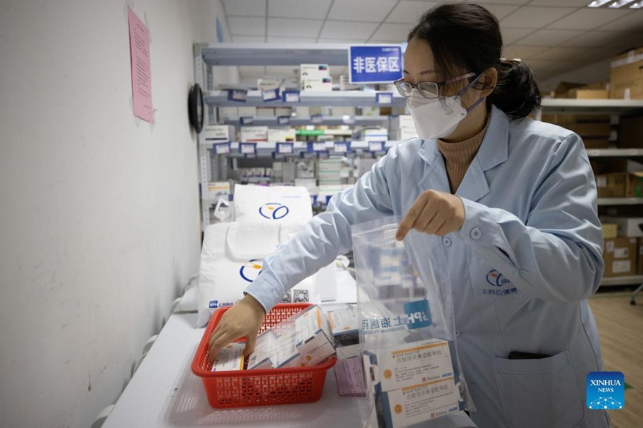Una farmacista mette i medicinali in sacchetti, insieme a ghiaccio istantaneo, presso la Shanghai Pharma E Pharmacy a Shanghai. (5 aprile 2022-Xinhua/Jin Liwang)