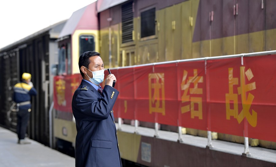 Un membro dello staff si coordina con un collega in merito alla partenza di un treno merci da una stazione merci a Lhasa, nella regione autonoma del Tibet della Cina sudoccidentale. (10 aprile 2022 - Xinhua/Zhang Rufeng)