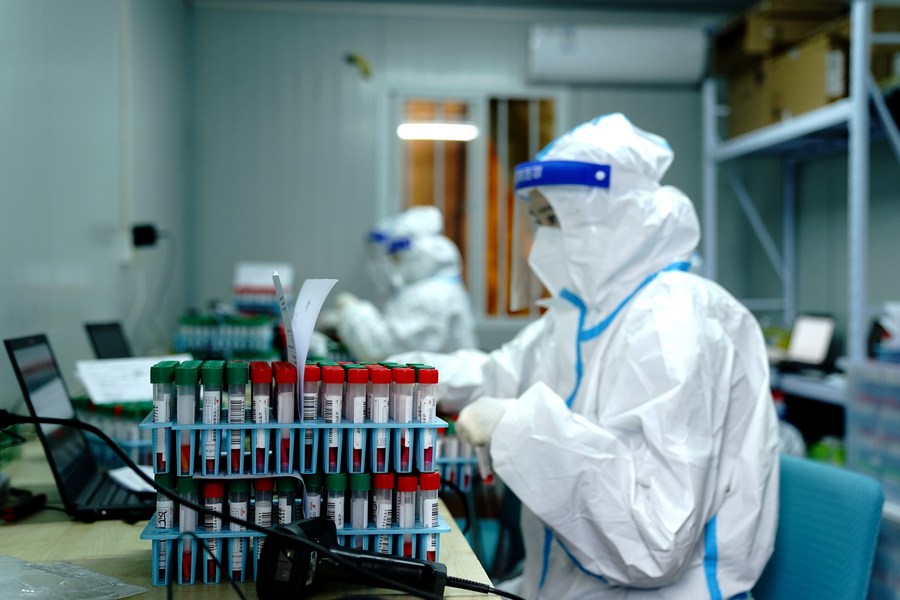 Gli operatori sanitari lavorano in un laboratorio di test COVID-19 a Shanghai, nella Cina orientale. (15 aprile 2022-Xinhua/Zhang Jiansong)