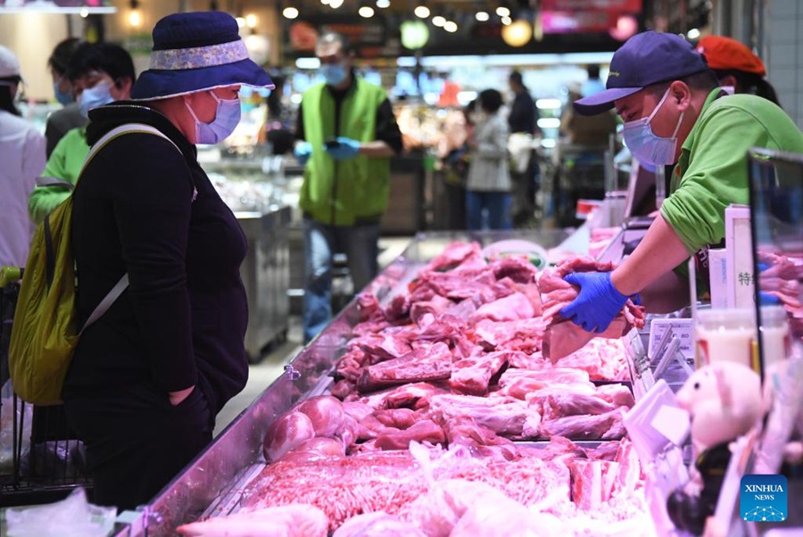 Una cittadina seleziona la carne in un supermercato nel distretto Haidian di Beijing, capitale della Cina. (26 aprile 2022 - Xinhua/Ren Chao)