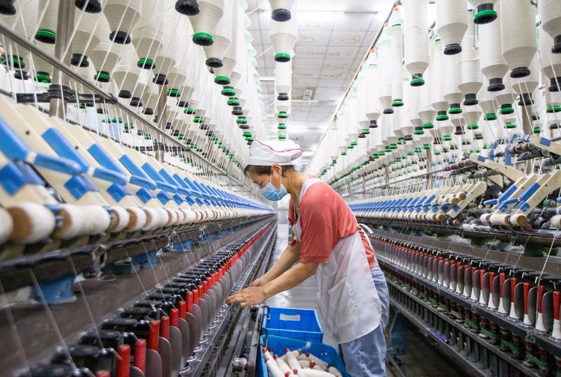 Una lavoratrice all'opera sulla linea di produzione di un'azienda tessile nel distretto di Nanmo, nella città di Hai'an, nella provincia del Jiangsu, nella Cina orientale. (28 febbraio 2022 - Xinhua/Zhai Huiyong)