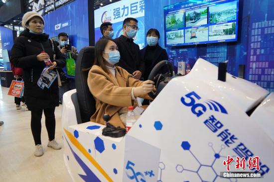 Visitatrice sperimenta il sistema di guida a distanza nella cabina di pilotaggio intelligente 5G della World Digital Industry Expo 2021. (26 maggio 2021 - China News Service)