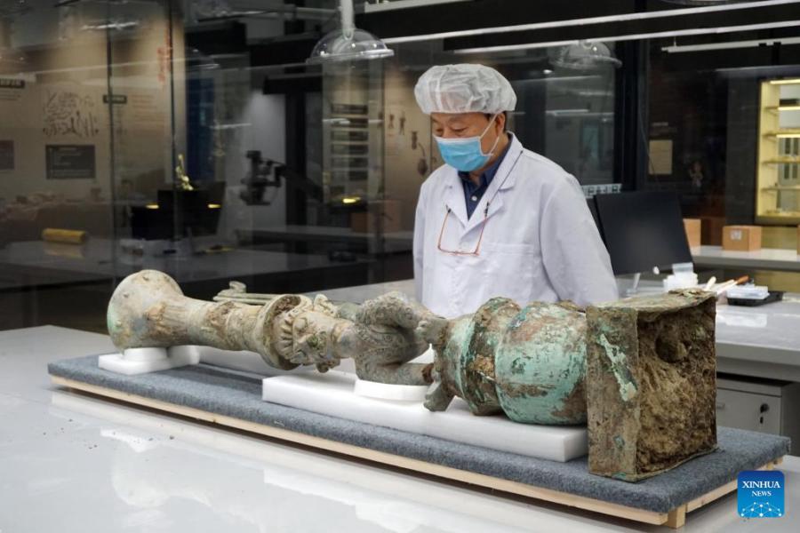 Lei Yu, ricercatore del Sichuan Provincial Cultural Relics and Archaeology Research Institute, osserva la scultura in bronzo recentemente abbinata con successo. (Xinhua/Xiao Lin) 