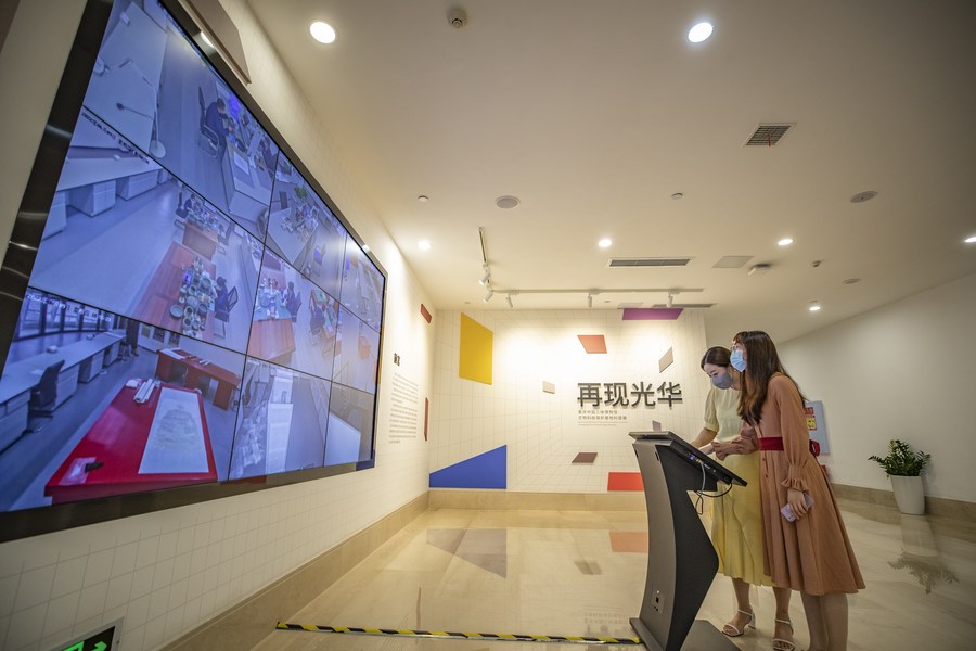 Due visitatrici osservano il lavoro di restauro dei reperti culturali attraverso telecamere ad alta risoluzione a 360 gradi presso la Base di Conservazione Scientifica e Tecnologica dei Reperti Culturali delle Tre Gole a Chongqing. (9 giugno 2022 - Xinhua/Huang Wei)