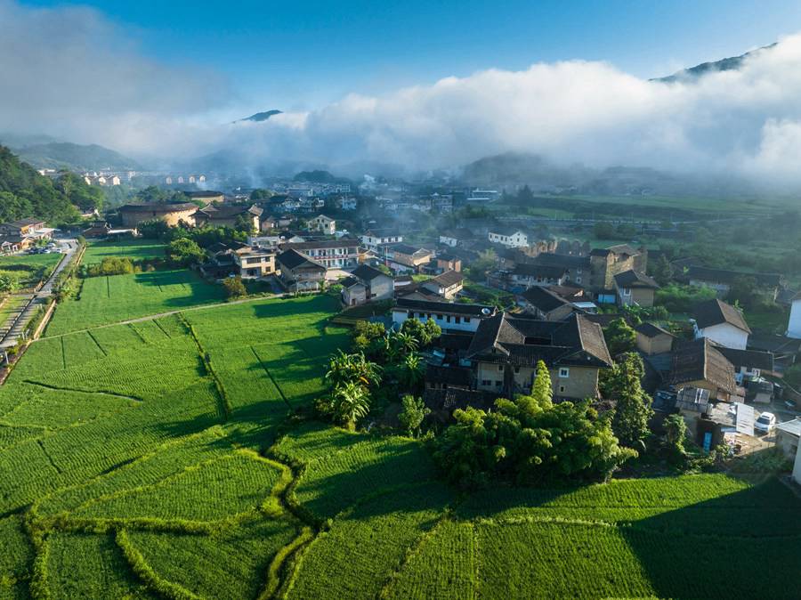 Vista mattutina dei Tulou del Fujian: un paese fatato avvolto da nuvole e nebbia