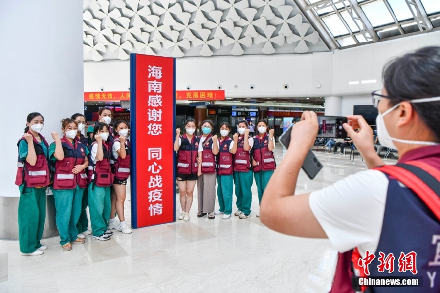 I membri della squadre di assistenza medica del Sichuan scattano una foto di gruppo al Terminal 1 dell'aeroporto internazionale di Haikou Meilan.