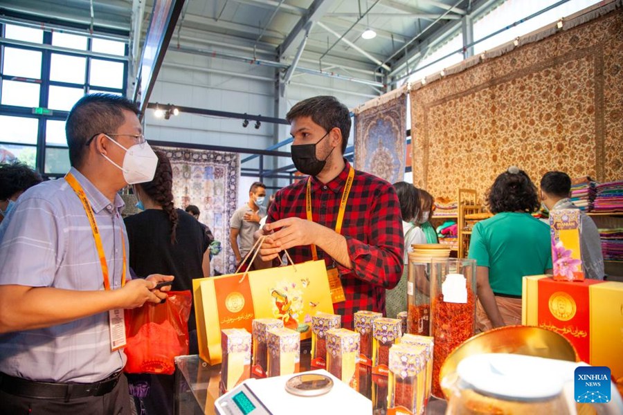 Un visitatore (a sinistra) fa acquisti presso lo stand dell'Iran in occasione di una mostra di servizi culturali e turistici al Parco Shougang durante la Fiera internazionale cinese del commercio di servizi (CIFTIS) del 2022 a Beijing. (5 settembre 2022 - Xinhua/Zhang Fan)