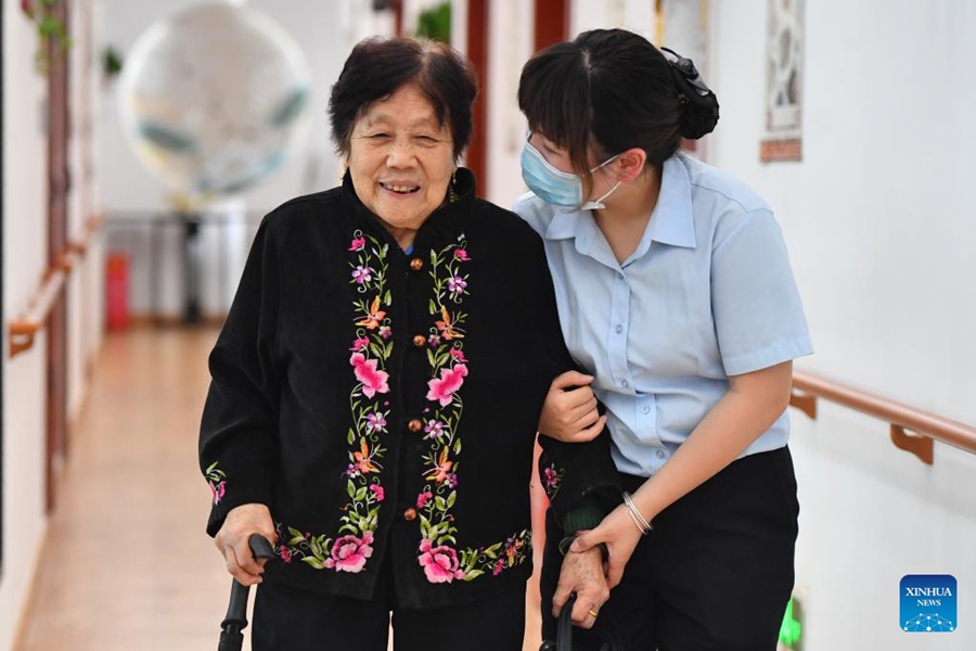 Liu Meng (a destra), un'infermiera, aiuta un'anziana a camminare in un centro di assistenza agli anziani nel distretto di Yuhu della città di Xiangtan, provincia dell'Hunan, Cina centrale. (17 maggio 2022 - Foto/Xinhua)