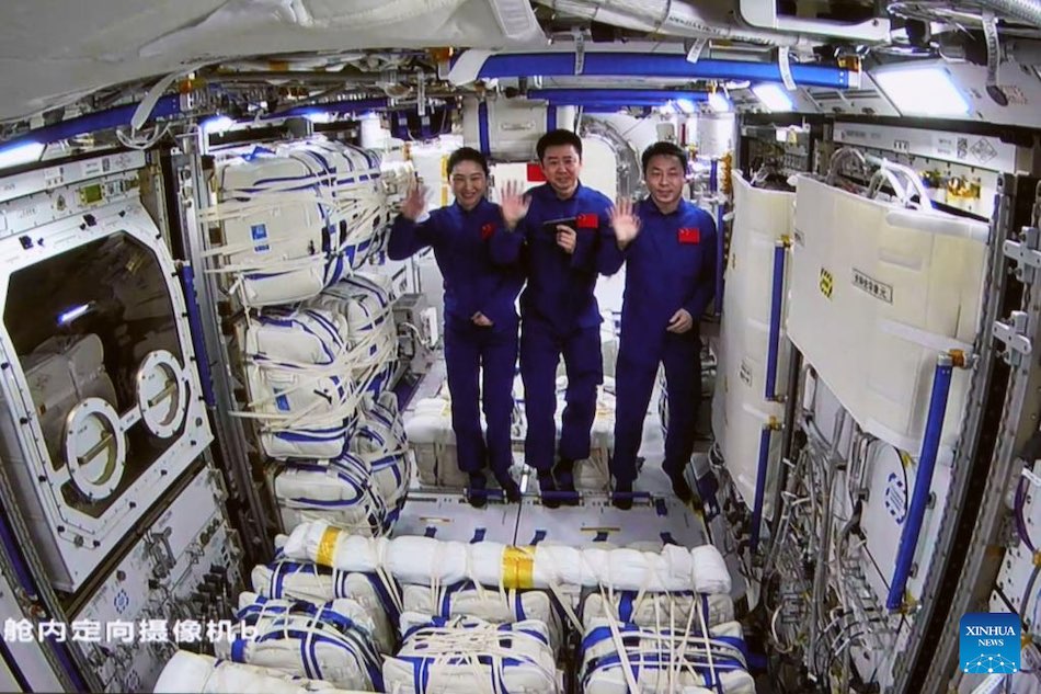 Fermo immagine mostra gli astronauti Shenzhou-14 Chen Dong (C), Liu Yang (sinistra) e Cai Xuzhe che salutano all'interno del modulo laboratorio Mengtian. (3 novembre 2022 - Sun Fengxiao/Xinhua)
