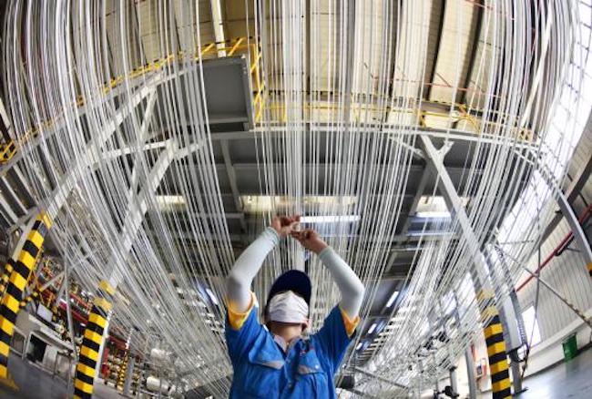 Un operaio controlla il funzionamento di una linea di produzione di fibra di carbonio in uno stabilimento di Lianyungang, nella provincia del Jiangsu. (Geng Yuhe/China Daily)