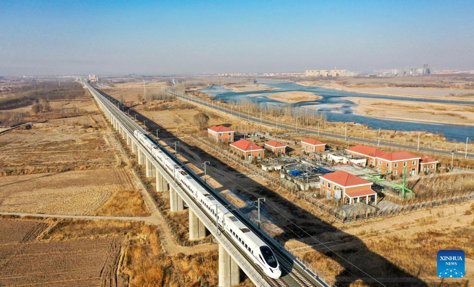 Vista aerea di un treno che passa accanto al fiume Giallo presso la città di Zhongwei, regione autonoma del Ningxia Hui, nella Cina nord-occidentale. (29 dicembre 2022 - Xinhua/Feng Kaihua)
