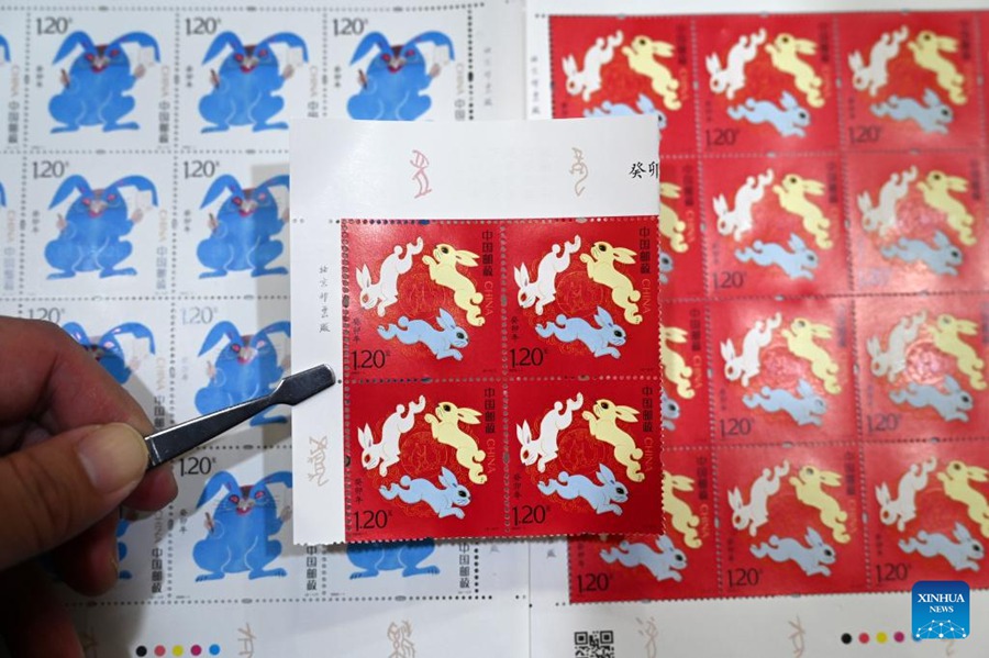 Un collezionista di francobolli mostra i francobolli speciali appena acquistati che segnano l'Anno del Coniglio nel distretto di Dongxing a Neijiang, nella provincia sud-occidentale del Sichuan. (5 gennaio 2023 - Lan Zitao/Xinhua)