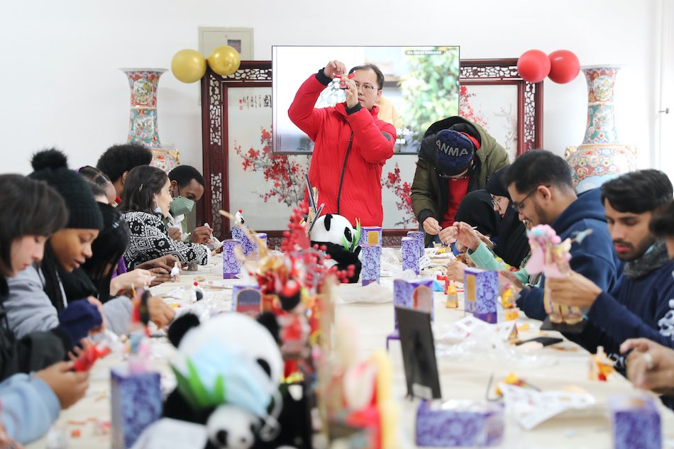 Qingdao, studenti stranieri fanno figurine di seta per festeggiare il capodanno cinese