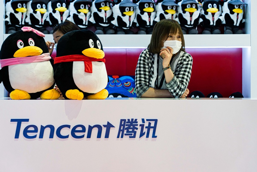 Una donna siede allo stand di Tencent Holdings Ltd durante una fiera a Shanghai. (China Daily/Fan Jianlei)