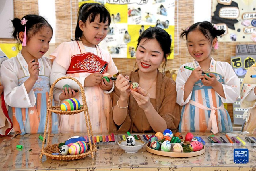 I bambini disegnano le uova colorate sotto la guida degli insegnanti nella Scuola dell'Infanzia Centrale nella contea di Xianju, provincia dello Zhejiang. (5 maggio 2023 – Xinhua/Wang Huabin)