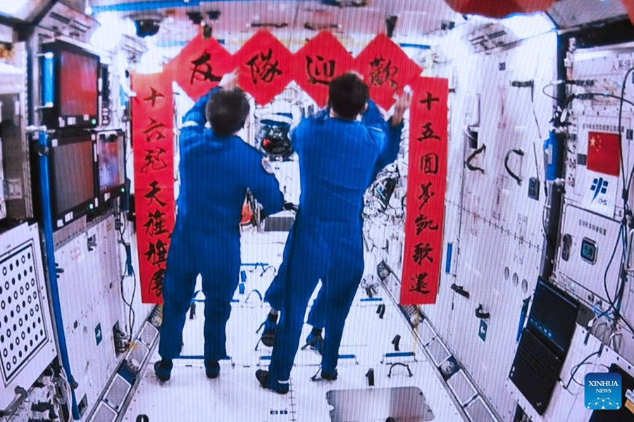 L'equipaggio della Shenzhou-15 affigge i distici di benvenuto per l'equipaggio della Shenzhou-16 all'interno del modulo centrale Tianhe della stazione spaziale cinese. (30 maggio 2023 - Xinhua/Li Jie)