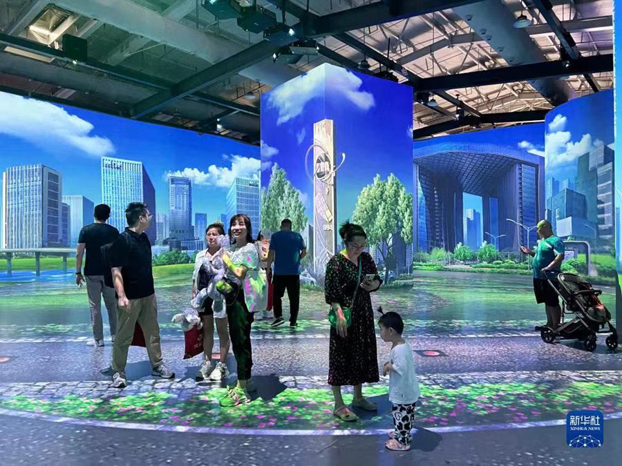 Spettatori visitano una città in realtà virtuale durante la CIFTIS 2023, nel Parco Shougang di Beijing. (5 settembre 2023 - Xinhua/Lu Zhe)