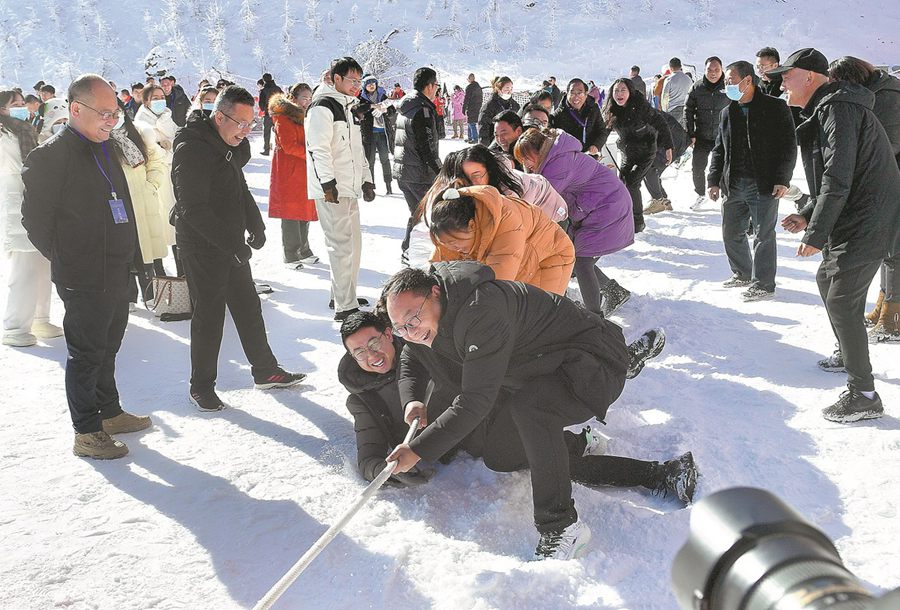 Turisti si divertono in un tiro alla fune sulla neve in una stazione sciistica di Hanzhong, nella provincia dello Shaanxi. (19 dicembre 2023 - Yuan Jingzhi/China Daily)