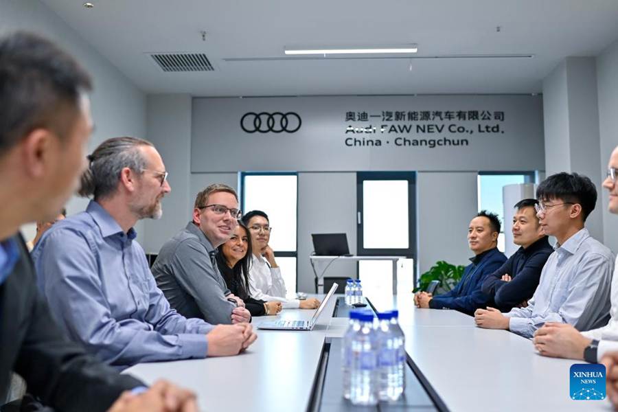 Gli ingegneri tedeschi Sascha Schuerrer (terzo a sinistra) e sua moglie Johanna Garzon-Schuerrer (quarta a sinistra) hanno un incontro in una sala conferenze presso l'Audi FAW NEV Co., Ltd. a Changchun, nella provincia del Jilin. (24 novembre 2023 - Xinhua/Yan Linyun)