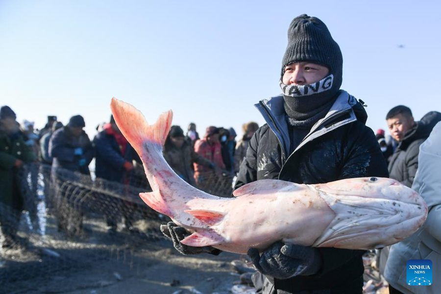 Un turista posa con un pesce durante il festival invernale della pesca sul lago Chagan nella città di Songyuan, nella provincia del Jilin, nel nord-est della Cina. (28 dicembre 2023 - Xinhua/Zhang Nan)