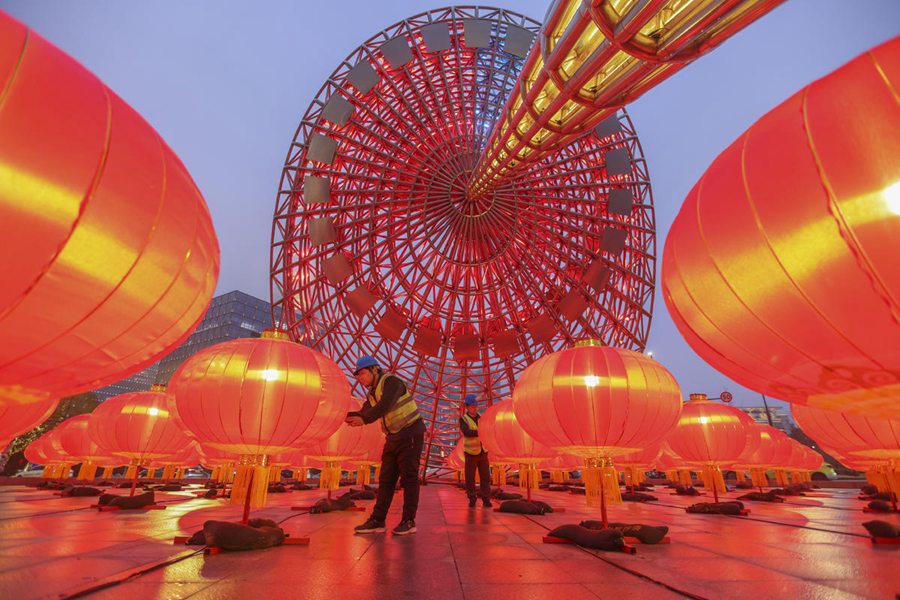 Membri dello staff effettuano un controllo finale delle lanterne sotto la grande scultura "Light of the Orient", nella Nuova Area di Pudong a Shanghai. (31 gennaio 2024 - Quotidiano del Popolo Online/Wangchu)