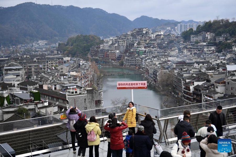 Turisti visitano un percorso turistico fuori da una stazione della linea espressa turistica maglev di Fenghuang, nell'antico borgo di Fenghuang, provincia dello Hunan. (1 febbraio 2024 - Xinhua/Chen Zhenhai)