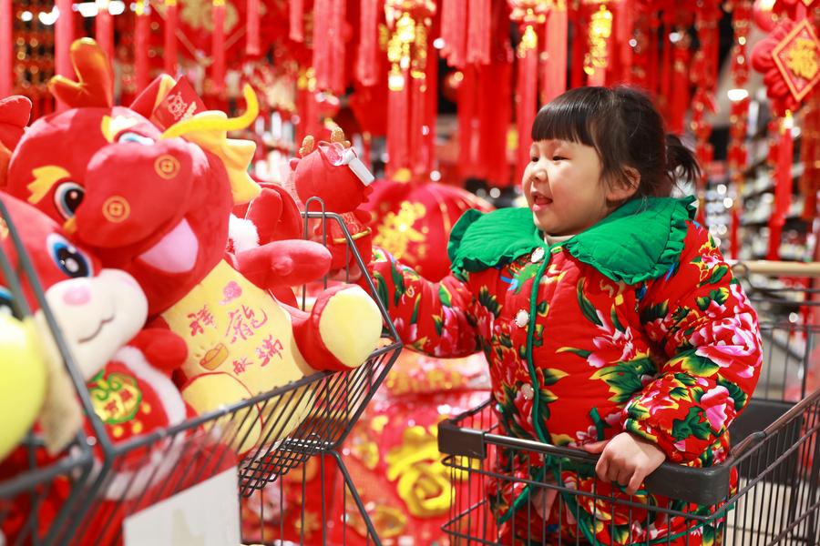 Una bambina guarda i peluche festivi in un supermercato nella contea di Cengong, nella provincia del Guizhou, sud-ovest della Cina. (23 gennaio 2024 - Tang Peng/Xinhua)