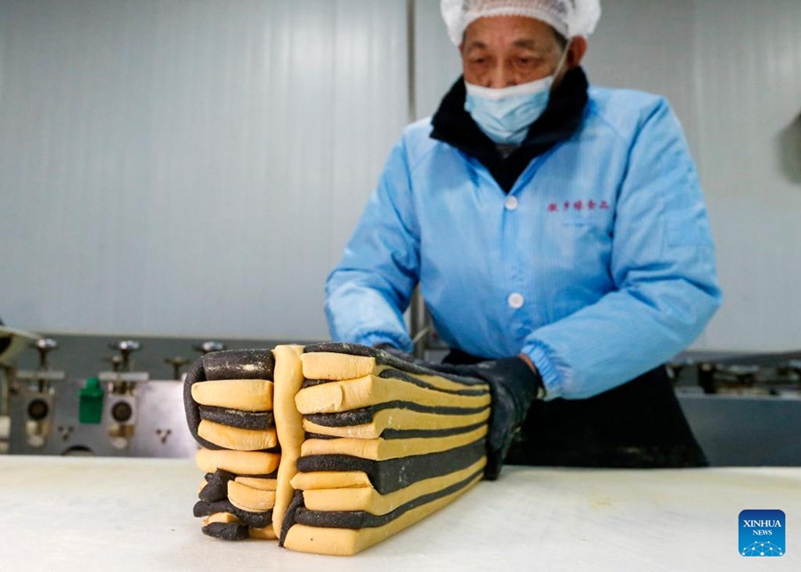 Artigiani impegnati nella produzione di caramelle intarsiate con caratteri cinesi