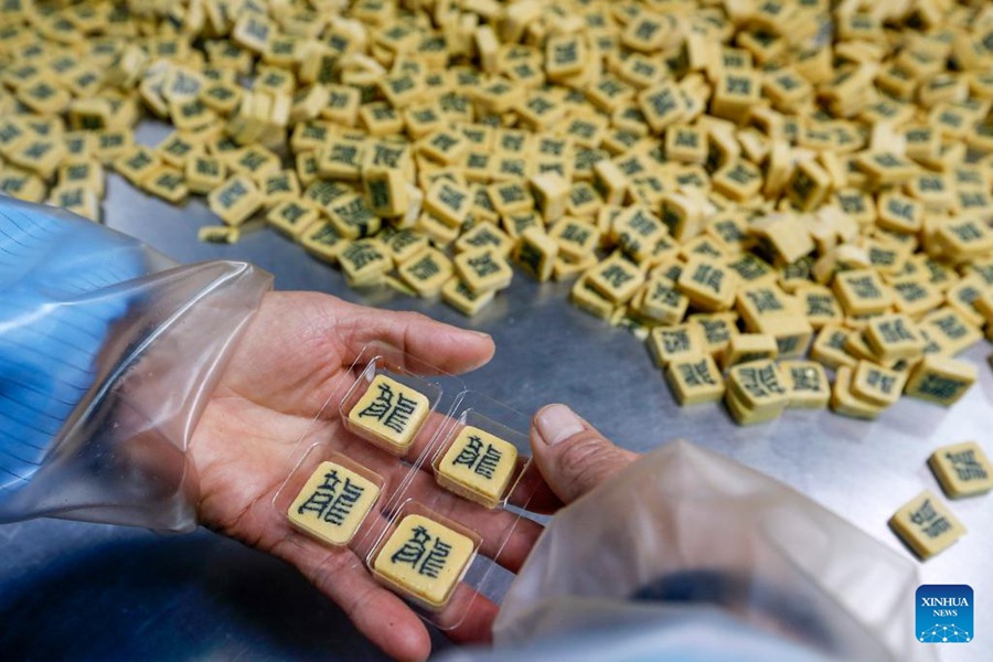 Artigiani impegnati nella produzione di caramelle intarsiate con caratteri cinesi