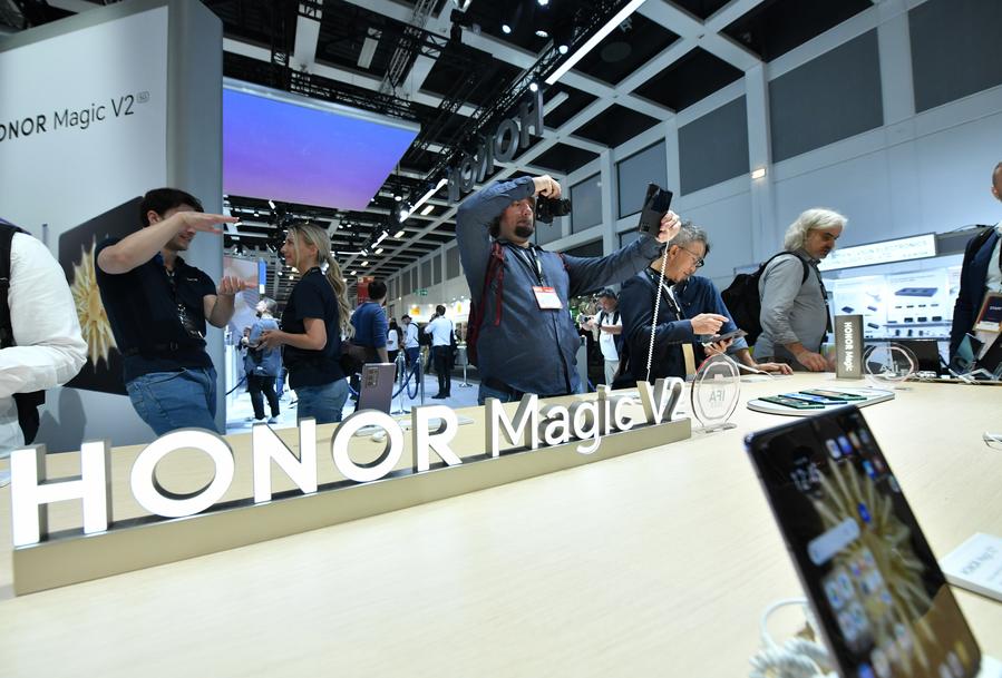 Persone provano telefoni pieghevoli allo stand dell'azienda cinese Honor durante l'IFA 2023 a Berlino, Germania. (1° settembre 2023 - Xinhua/Ren Pengfei)