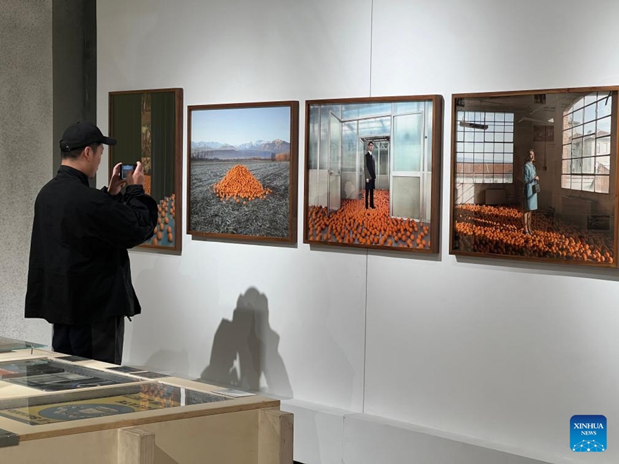 Un visitatore scatta foto alla mostra "Universo Olivetti. Comunità come utopia concreta" presso il complesso edilizio Jiulongyiku nella municipalità di Chongqing. (5 marzo 2024 - Xinhua/Yang Shiyan)
