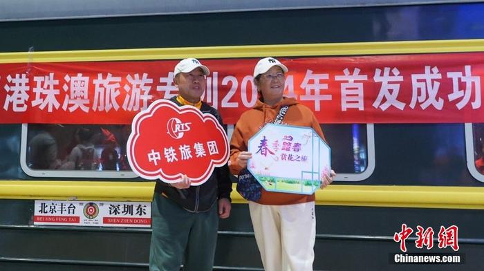 Passeggeri posano per una foto alla stazione Fengtai di Beijing davanti al treno turistico speciale da Beijing al ponte Hong Kong-Zhuhai-Macao. (20 marzo 2024 - Foto/Chinanews.com)