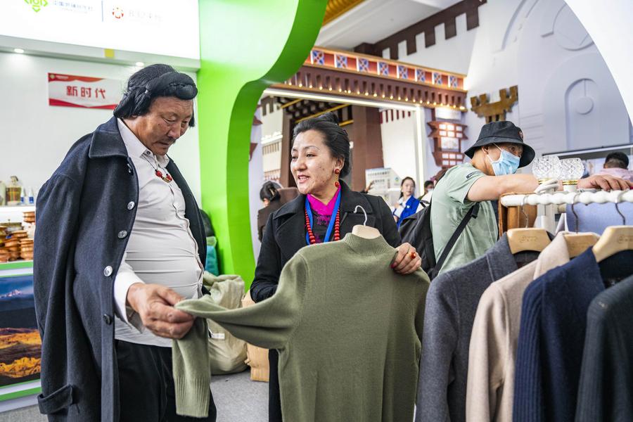 Un membro dello staff presenta abiti in cashmere durante la quinta edizione dell'Expo del turismo e della cultura dello Xizang cinese, a Lhasa, nella regione autonoma dello Xizang. (17 giugno 2023 - Xinhua/Sun Fei)