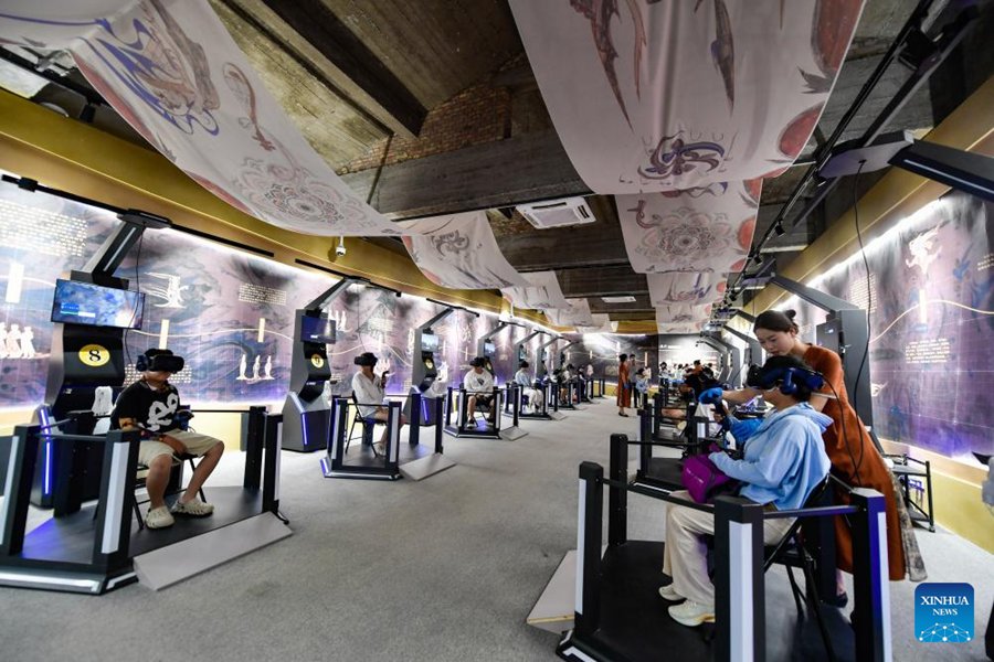 Visitatori utilizzano dispositivi VR per visitare le Grotte di Mogao a Dunhuang, nella provincia del Gansu. (22 luglio 2024 – Xinhua/Lang Bingbing)