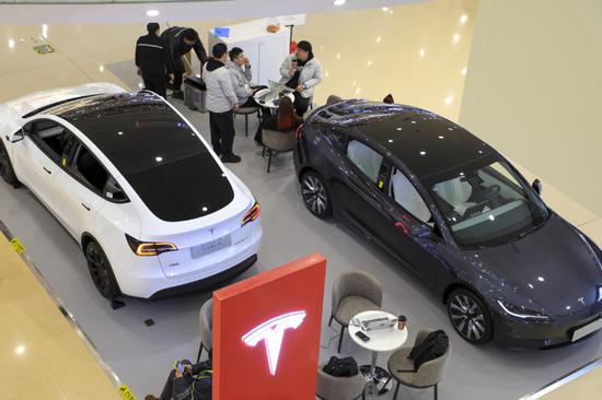 Clienti in uno showroom Tesla a Shanghai. (China Daily)