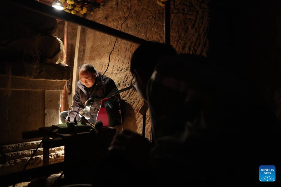 Mu Changyou, restauratore di beni culturali dell'Istituto d'arte delle Grotte del monte Maiji, svolge lavori di protezione e restauro in una delle Grotte del monte Maiji nella città di Tianshui, provincia del Gansu. (2 novembre 2024 – Xinhua/Chen Bin)