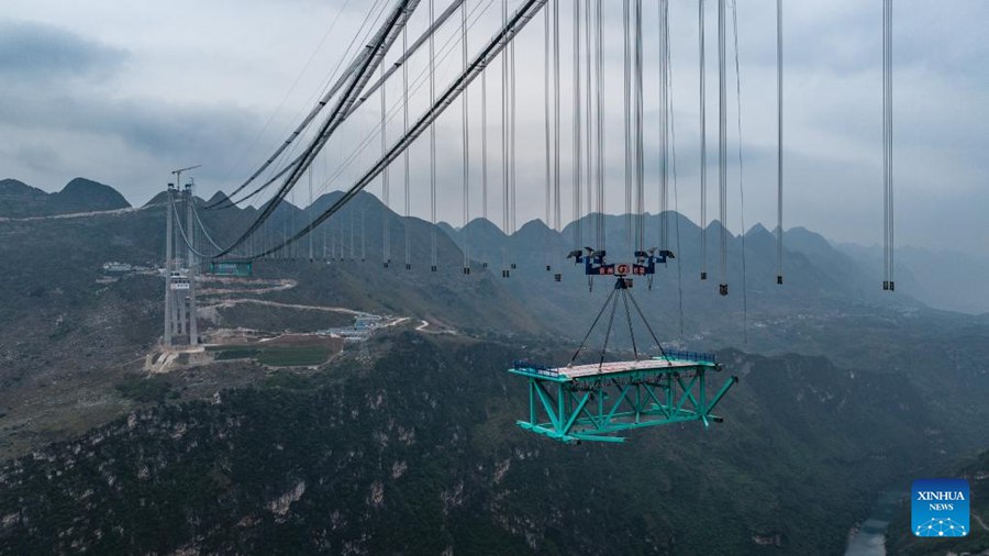 Prima trave reticolare in acciaio del ponte sul Huajiang Grand Canyon sollevata nella posizione designata