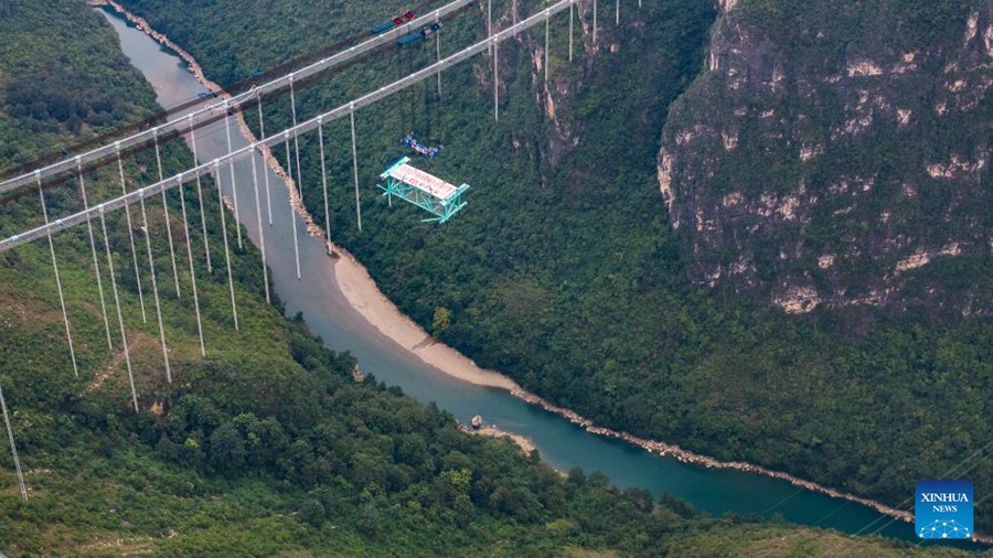 Prima trave reticolare in acciaio del ponte sul Huajiang Grand Canyon sollevata nella posizione designata