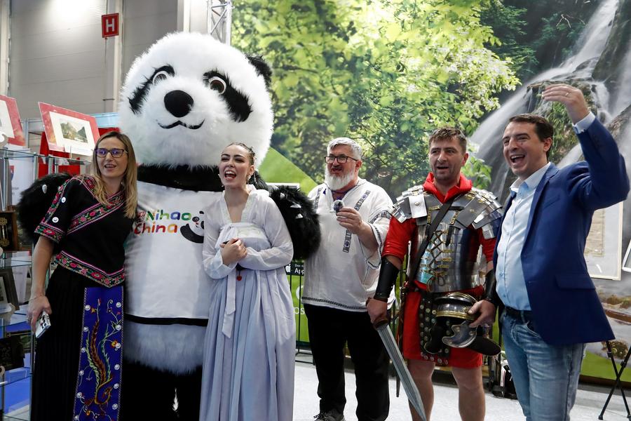 Visitatori posano per delle foto con la mascotte panda gigante dello stand cinese all'edizione autunnale della Fiera del turismo della Romania a Bucarest, Romania. (22 novembre 2024 - Xinhua/Cristian Cristel)