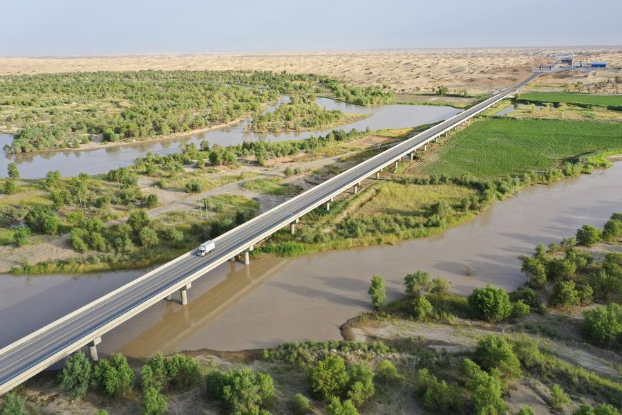 Sezione di una nuova autostrada desertica che attraversa il deserto del Taklimakan sopra il fiume Tarim nella regione autonoma uigura dello Xinjiang, Cina nord-occidentale. (22 giugno 2022 - Xinhua/Li Xiang)