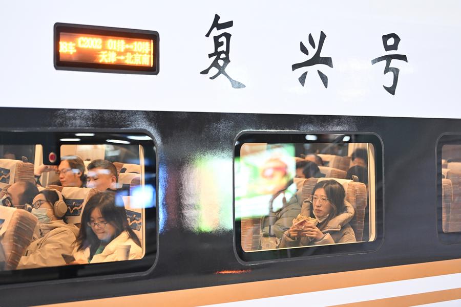 Passeggeri su un treno ad alta velocità diretto a Beijing alla stazione ferroviaria di Tianjin, nella Cina settentrionale. (10 dicembre 2024 - Xinhua/Li Ran)