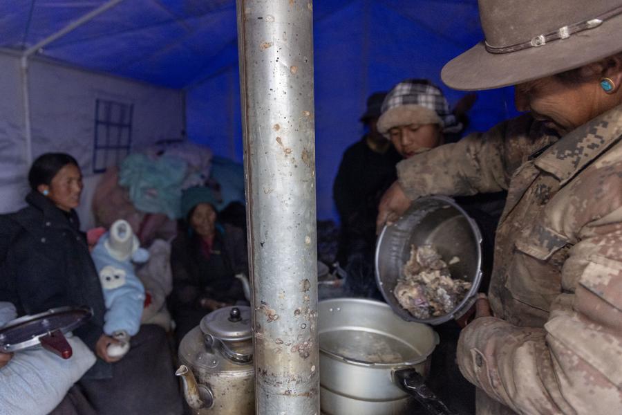 I residenti colpiti dal terremoto cucinano in una tenda in un villaggio a Xigaze, nella regione autonoma dello Xizang, Cina sud-occidentale. (7 gennaio 2025 - Xinhua/Jiang Fan)