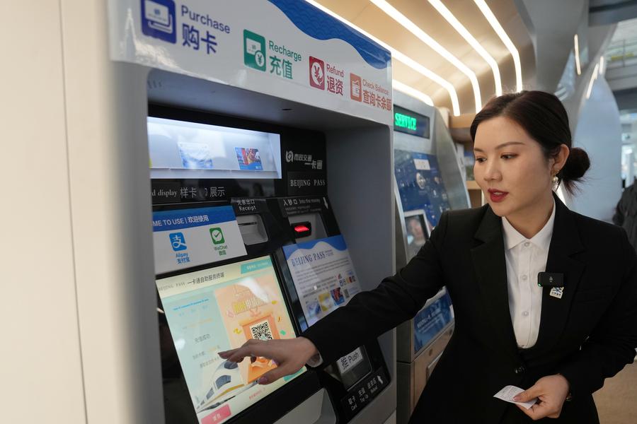 Membro dello staff presenta il processo di ricarica del Beijing Pass, presso uno sportello di assistenza dell'aeroporto internazionale di Beijing, capitale della Cina. (8 gennaio 2025 - Xinhua/Ju Huanzong)