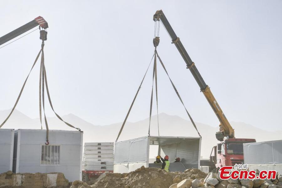 Lavoratori costruiscono case a pannelli nel borgo di Quxar, nella contea di Dingri, a Xigaze, nella regione autonoma dello Xizang, nel sud-ovest della Cina. (10 gennaio 2025 - China News Service)