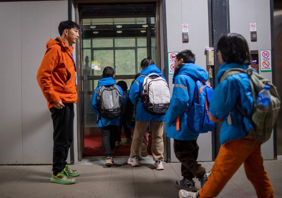 Studenti del villaggio di Nizhuhe si preparano a prendere un ascensore turistico mentre si dirigono a scuola nel borgo di Puli, città di Xuanwei, provincia cinese sud-occidentale dello Yunnan. (23 febbraio 2025 - Xinhua/Jiang Wenyao)